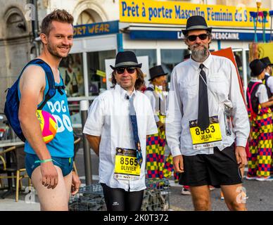 Baywatch and Blues Brothers. Before the Marathon des Chateaux du Medoc starts, there is the defilee of the costumes. Famous film music blares from loudspeakers and the mood among the participants is excellent. Many run in groups or as a pair and again and again the motto 'film' is taken up Stock Photo