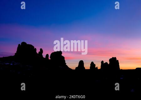 Colorful sunset skies over sandstone towers in the Windows Section of Arches National Park near Moab, Utah. Stock Photo