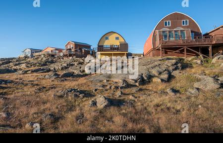 Houses on a rocky ridge in the city of Iqaluit in Nunavut, Canada Stock Photo