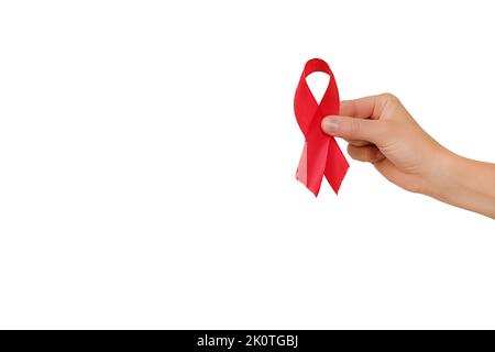 Close-up of female hand holding small red ribbon, posing isolated over white studio background wall with copy space for promotion content or design. H Stock Photo