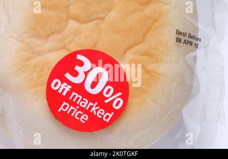 Discount sticker attached to cellophane bread packaging. 30 per cent off marked price. Best before date printed on packaging Stock Photo
