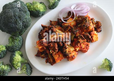 Tandoori paneer broccoli. Cottage cheese cubes and broccoli florets marinated with yogurt and spices and air fried. Healthy starter or an evening snac Stock Photo