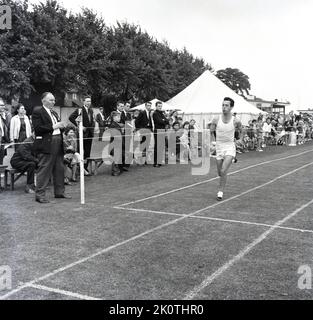 Vintage Running Races 1960s, historical, athletics, outside on a cinder track, three young ...