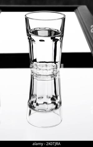 A glass with clean clear water with reflection and sharp shadows. Top view. Stock Photo