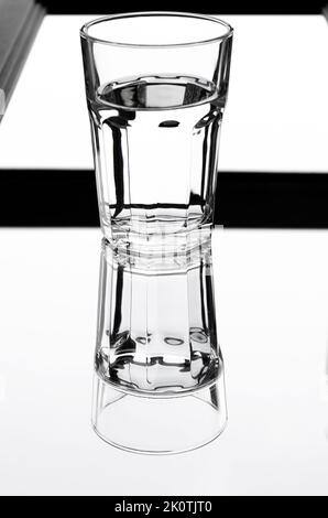 A glass with clean clear water with reflection and sharp shadows. Top view. Stock Photo