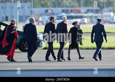 The Princess Royal (second right)and Vice Admiral Sir Tim Laurence (third left) as the coffin of Queen Elizabeth II is met at Edinburgh Airport by a guard of honour from the Royal Regiment of Scotland on its journey from Edinburgh to Buckingham Palace, London, where it will lie at rest. Picture date: Tuesday September 13, 2022. Stock Photo