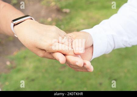 Close-up of hands of bride and groom with ring on finger. Happy couple celebrating wedding outdoors Stock Photo