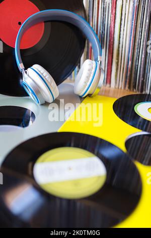 Headphones and several messed up vinyl records. Concept of listening to music. Stock Photo