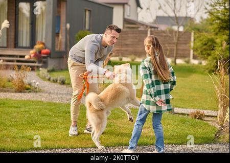 Father and daughter spending time with their dog Stock Photo