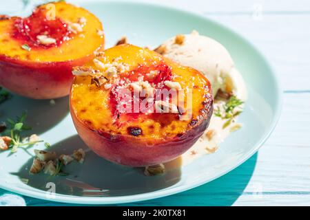 Grilled peaches with vanilla ice cream and honey. Stock Photo