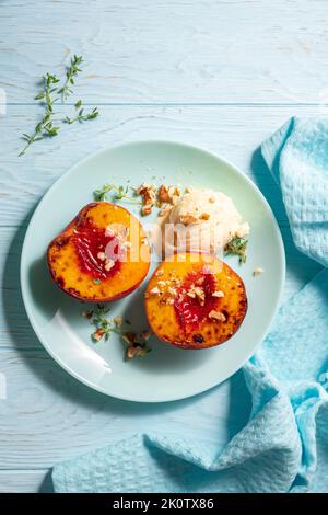 Grilled peaches with vanilla ice cream and honey. Stock Photo