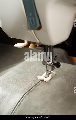 Modern sewing machine special presser foot with beige corduroy fabric ...