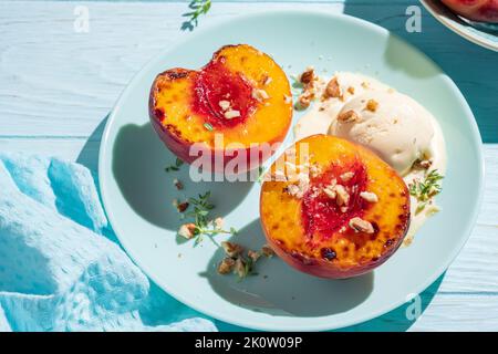 Grilled peaches with vanilla ice cream and honey. Stock Photo