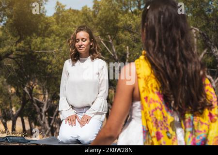 women on a mindfulness therapy on the forest. Happy coach leading meditation Stock Photo