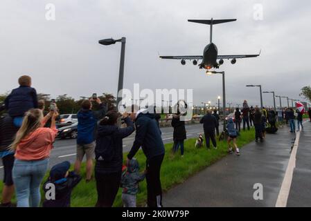 RAF Northolt, South Ruislip, London, UK. 13th Sep, 2022. The body of Queen Elizabeth II has been flown from Edinburgh Airport by Royal Air Force Boeing C-17A Globemaster III serial number ZZ177 and is seen on finals to land at RAF Northolt in London. The coffin will then be transferred to road transport for the journey to Buckingham Palace. The large transport aircraft landed over the A40 and members of the public that had braved the evening rain. People taking photographs with mobile phones Stock Photo