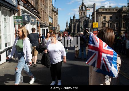 Edinburgh, UK. 13th Sep, 2022. A lady is seen with a union jack flag in front of the St. Giles' Church where Queen Elizabeth II was laying at rest. Crowds turned out to see the royal procession and pay the respects. Edinburgh, Scotland. September 13, 2022 (photo by Hale Irwin/SIPA USA) Credit: Sipa USA/Alamy Live News Stock Photo