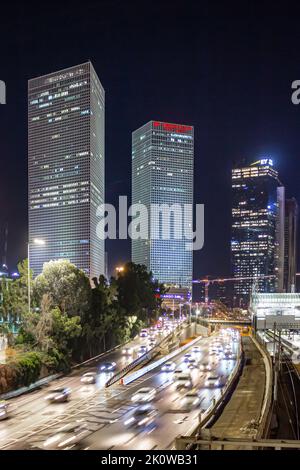 long exposure of cars in the city with buildings in the background at night. busy highway beneath office buildings. Stock Photo