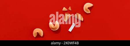 Fortune cookies on red background with deep long shadows. Blank paper for prediction words Stock Photo