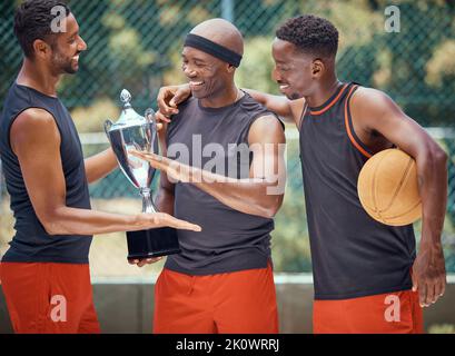 Award, success and basketball athletes with a trophy as a reward or prize after winning a competitive sports game. Challenge, fitness and happy Stock Photo