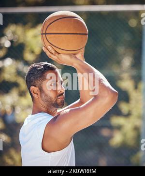 Basketball player, sports and training with fitness man with ball ready to shoot or throw while playing at an outdoor court. Serious athlete doing Stock Photo