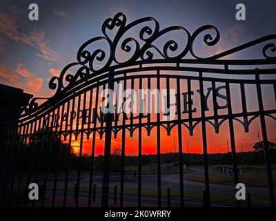 Sunset behind gates to Grappenhall Heys, South Warrington, Cheshire, England, UK,  WA4 3LG Stock Photo