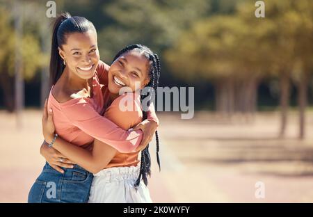 Portrait of happy friends hugging and smile outside in the park. Happy african american females embracing each other, spending the day together in the Stock Photo