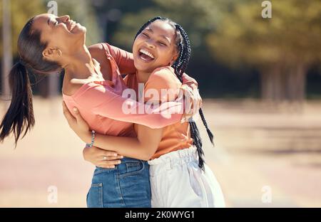 Happy friends or women hug and laugh together in nature at a park or forest. Smiling, playful sisters embracing, bonding, enjoying a day outdoor and Stock Photo