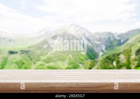 Wood table top stand with blur mountain landscape view background in spring. Food product display with nature concept backdrop. Stock Photo