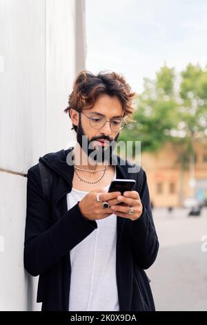 stylish young man typing on mobile phone Stock Photo
