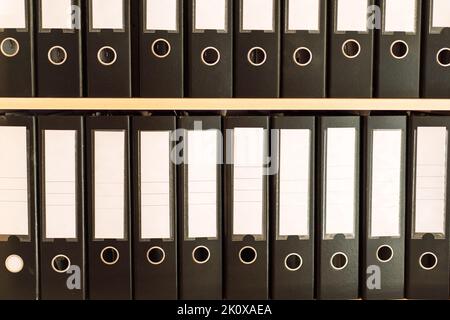 Black office folders standing on cabinet shelves Stock Photo