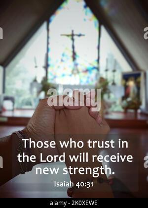 Bible verse quote - Those who trust in the Lord will receive new strength. Isaiah 40:30 With holding hands of mom and daughter on blurry background of Stock Photo