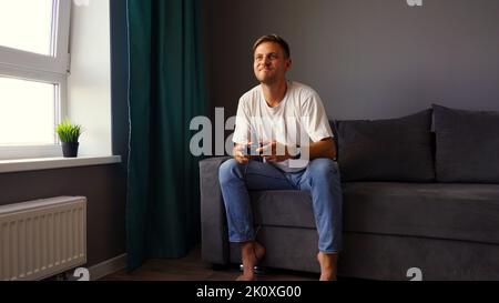 Excited young handsome man playing video game  Stock Photo