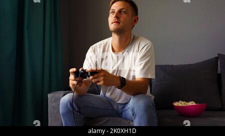 Excited young handsome man playing video game  Stock Photo