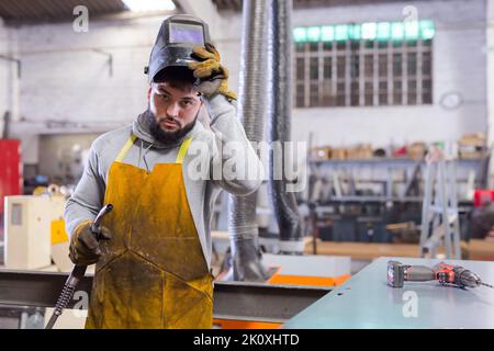 Man using welder for construction work at the workshop Stock Photo