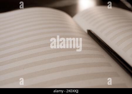 Empty music sheet with pencil. Music learning background. Open blank sheet music notebook. Close up, shallow depth of field. Conservatory, music, shee Stock Photo