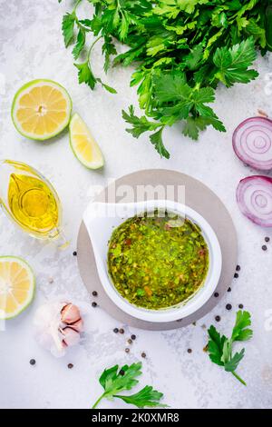 Chimichurri - homemade fresh Latin American sauce made from various herbs, garlic and red wine vinegar. Cooking ingredient or table condiment Stock Photo