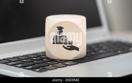 Wooden block with symbol of fafsa concept on laptop keyboard Stock Photo