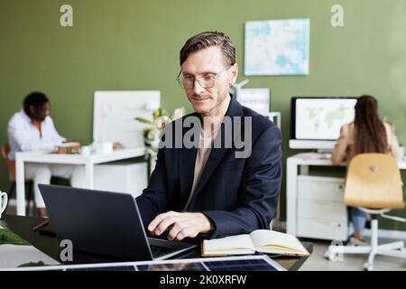 Businessman working online on laptop at his workplace at office Stock Photo