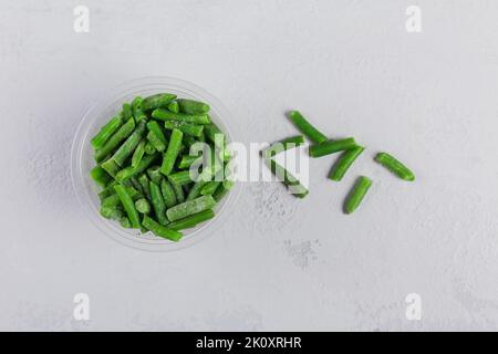 Top view composition with different organic frozen vegetables on a white concrete background Stock Photo