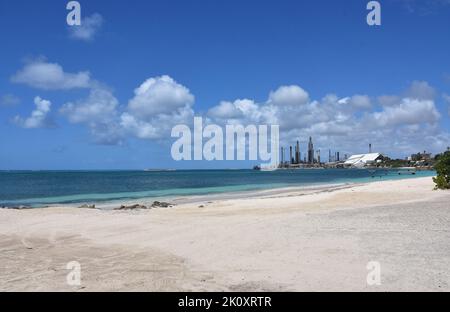 Oil refinery views from the white sands of Rodgers Beach in Aruba. Stock Photo