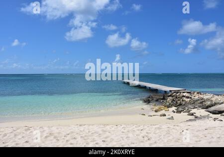 Beautiful seascape with a long dock and a white sand beach in Aruba. Stock Photo