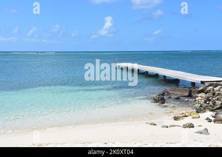 Dock extending into the waters off of Rodgers Beach in Aruba. Stock Photo