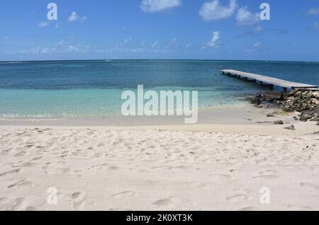 Narrow pier jutting into the ocean on Rodgers Beach in Aruba. Stock Photo