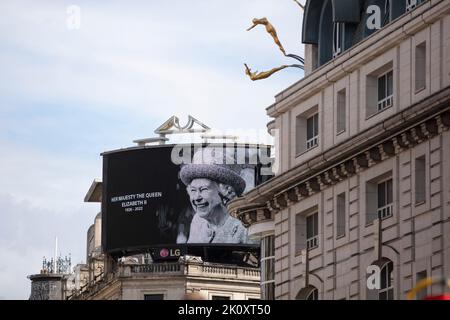 LONDON, UK - September 2022: A portrait of Queen Elizabeth II is shown on a large screen in Piccadilly Circus after her death Stock Photo