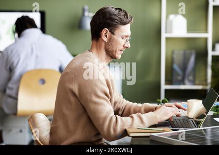 Serious businessman working online using his laptop at table at office Stock Photo