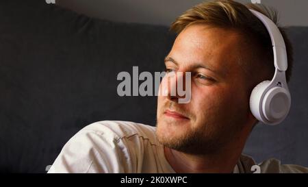 A happy young man enjoys listening to music Stock Photo