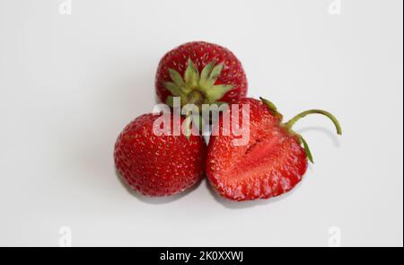 The whole strawberries and half isolated on white background Stock Photo