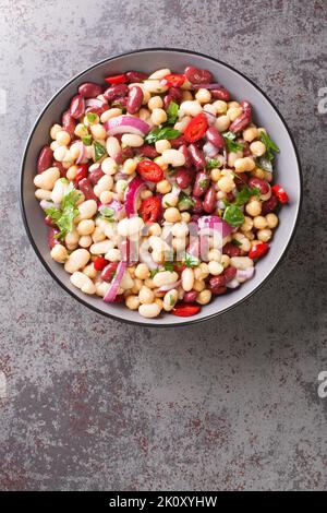 Three bean salad with chili and onion Delicious vegetarian food close-up in a plate on the table. Vertical top view from above Stock Photo