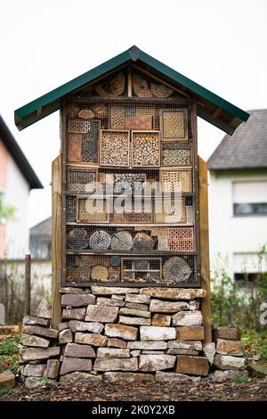 Large and beautiful wood and stone insect hotel created to provide shelter for insects like bees to prevent extinction in residential area. Stock Photo