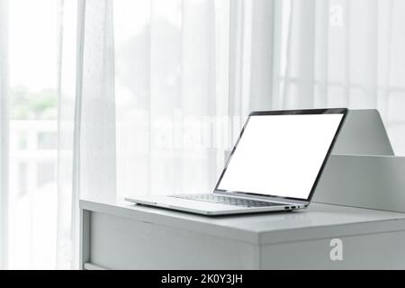 Computer laptop with blank screen on white table in home interior or office background Stock Photo